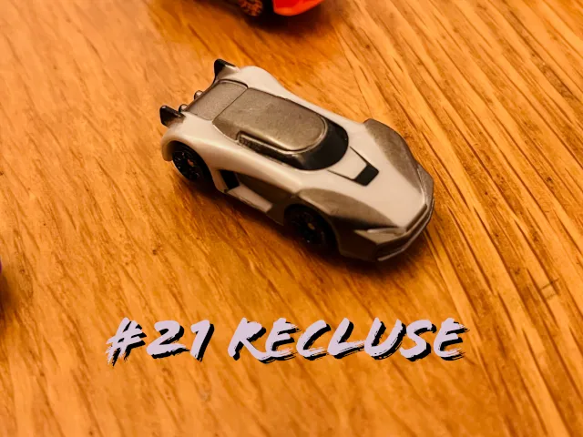 A carousel photo displaying the twenty-first vehicle named 'Recluse' out of an array of 'Deluxe Cars', at full size. The car is painted mostly black with shades of grey across the front.